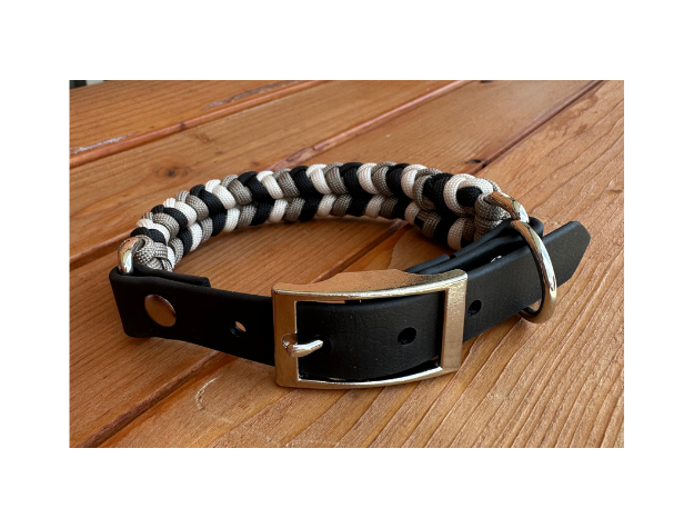 Dog collar with striped pattern and black leather buckle on a wooden surface