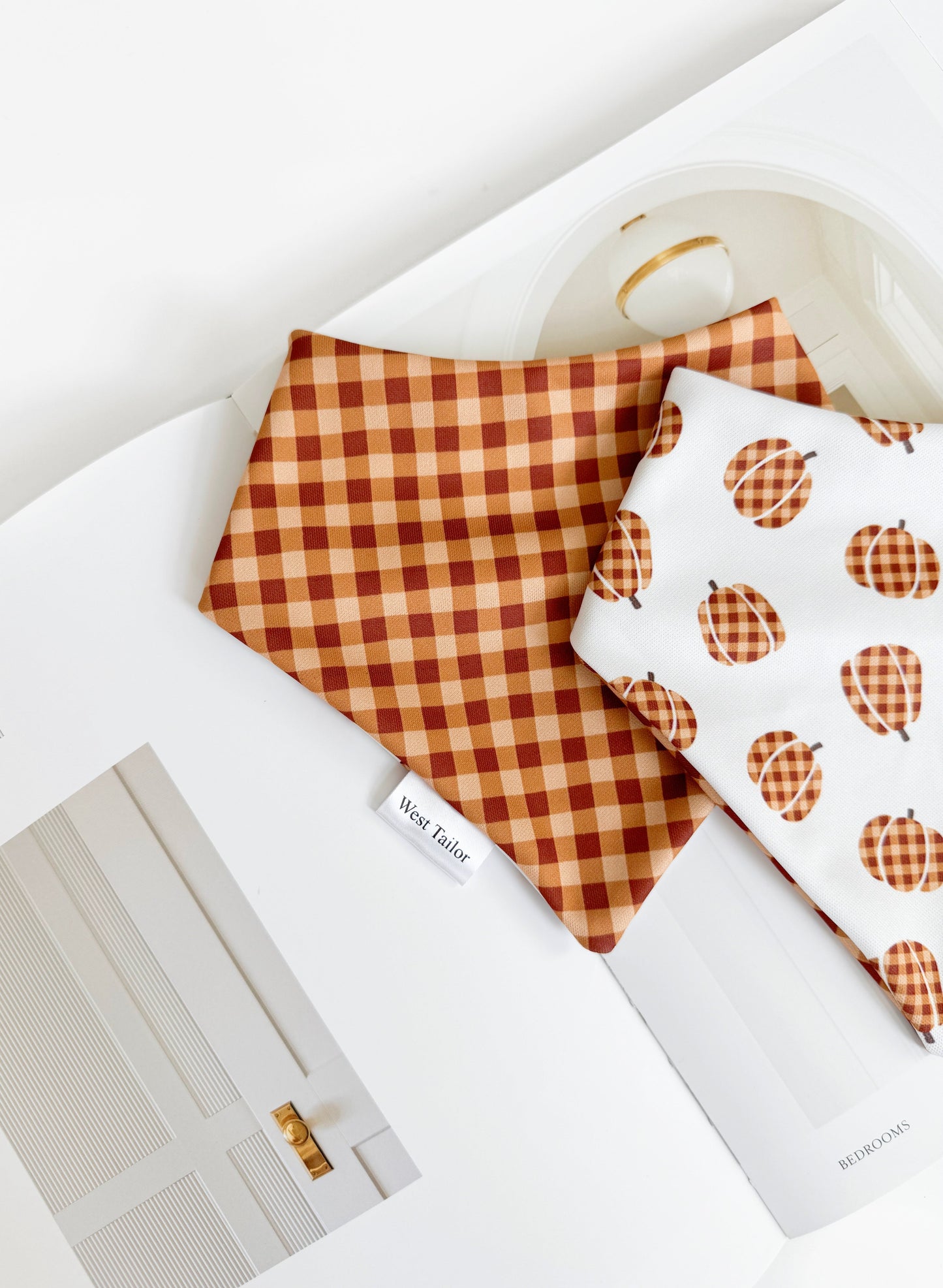 Checkered and pumpkin-patterned bandana on a white surface