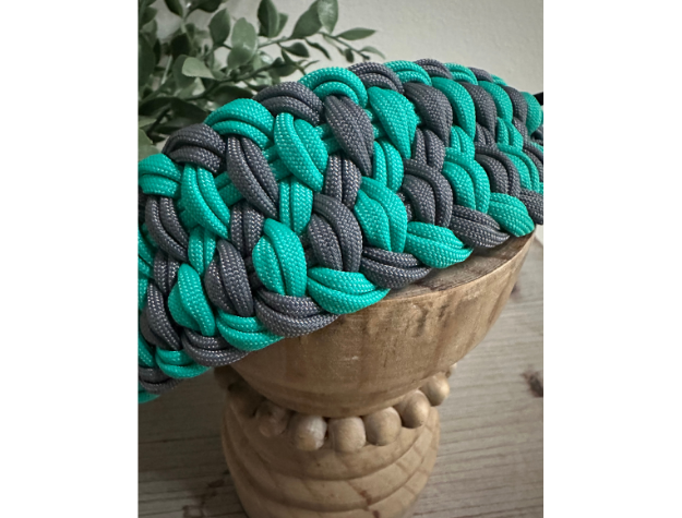 Teal and gray braided dog collar on a wooden stool with a natural background