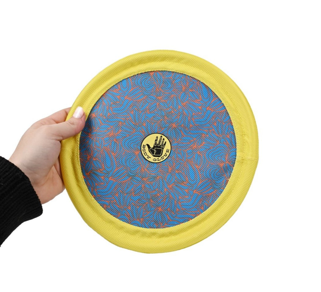 Hand holding a yellow frisbee with a blue center and visible brand logo on a white background