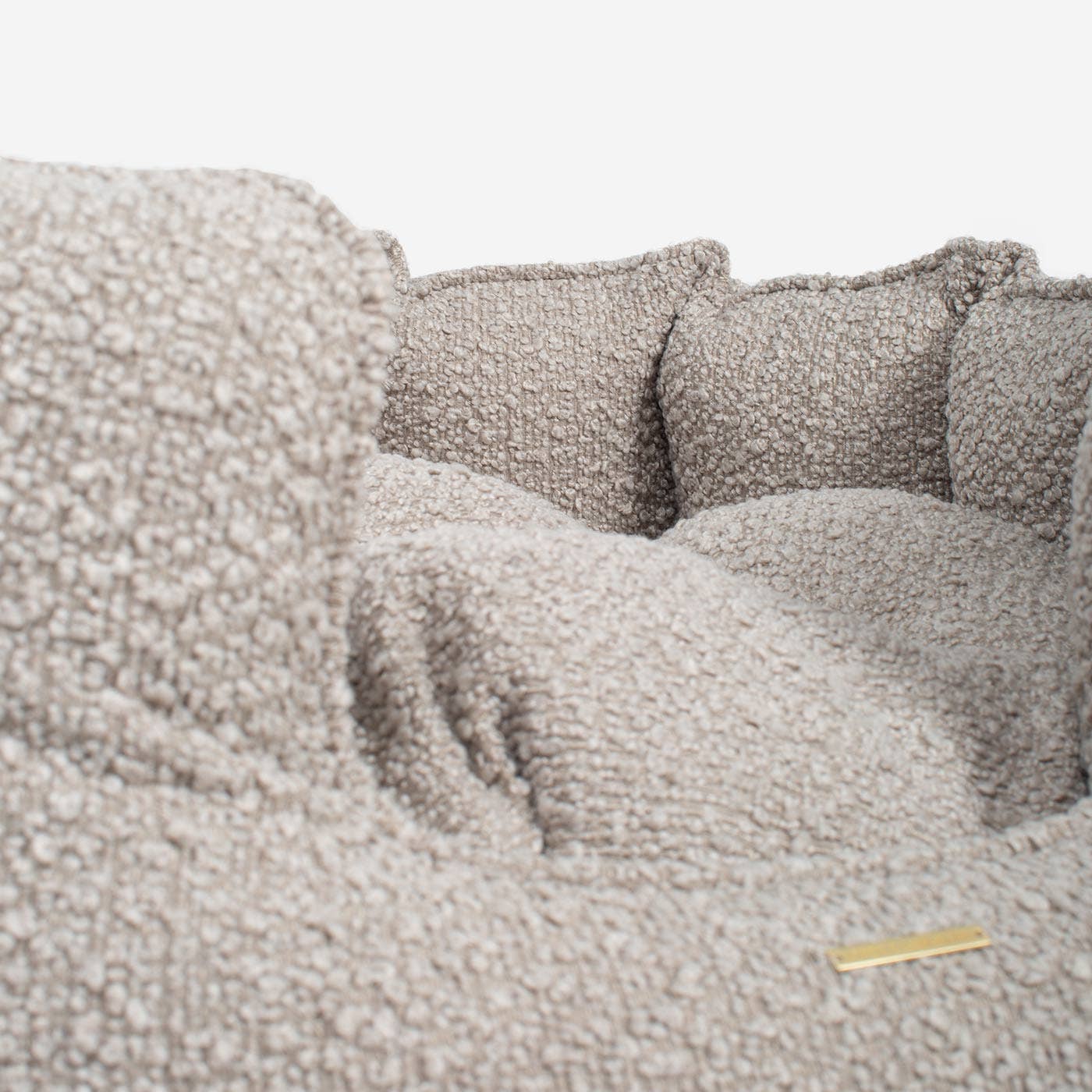 Close-up of a textured gray sofa with cushions on a light background