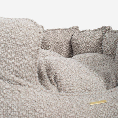 Close-up of a textured gray sofa with cushions on a light background