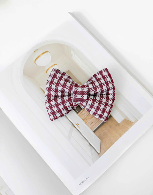 Red and white checkered dog bow tie on a white surface
