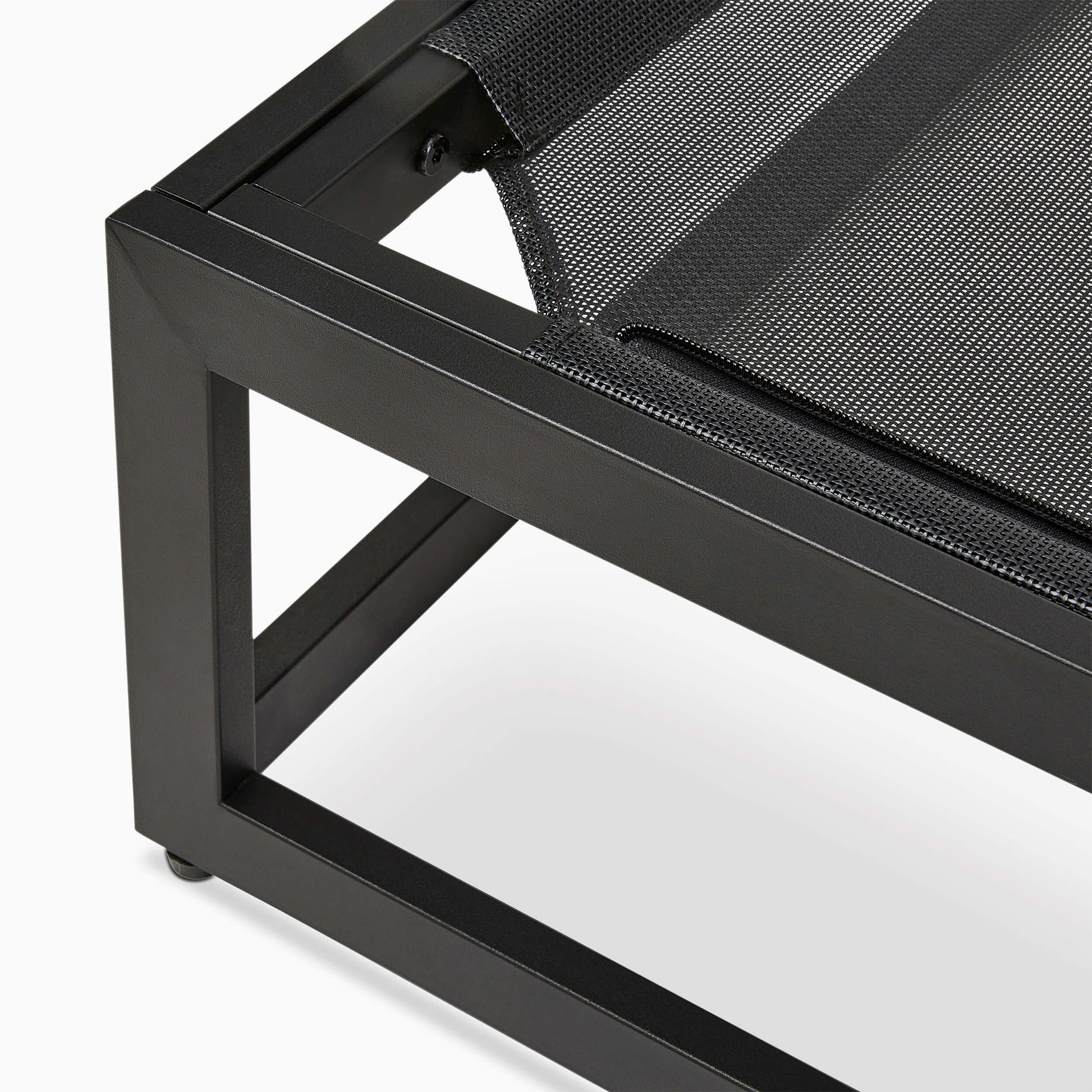 Close-up of a black metal chair with a textured black cushion on a white background