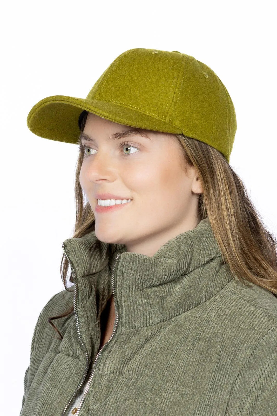 Woman wearing a green cap and jacket on a white background