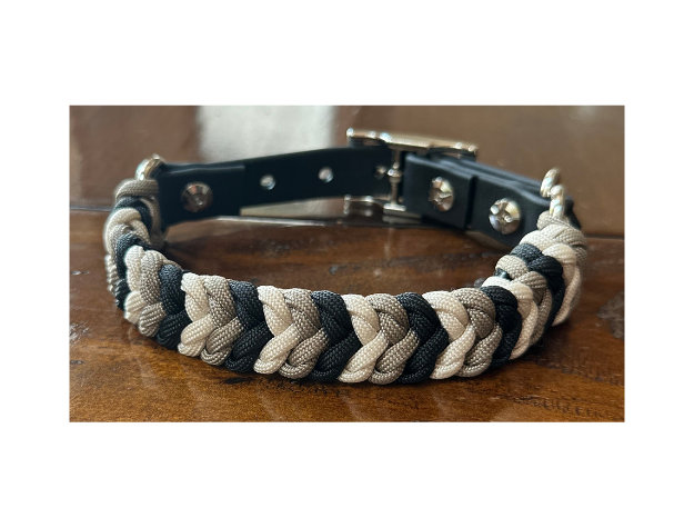 Braided dog collar with black and beige pattern on a wooden surface