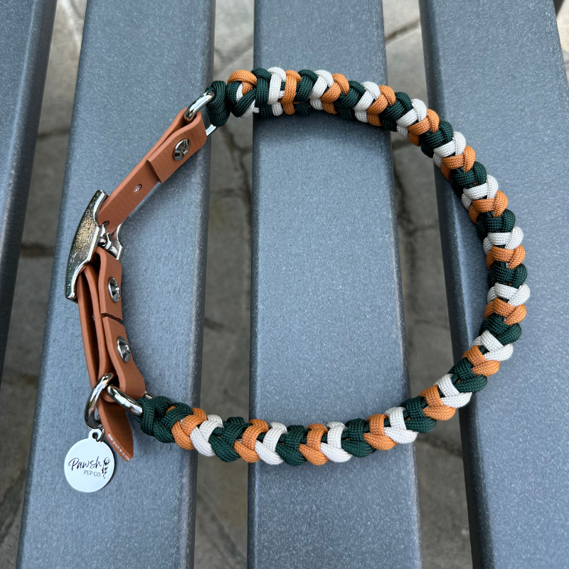 Dog collar with braided design in green, yellow, and white on a metal stand.