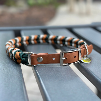 Dog collar with braided design in green, yellow, and white on a metal stand.