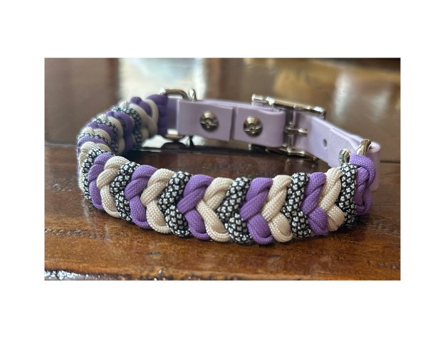 Braided dog collar with purple and beige pattern on a wooden surface