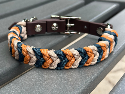 Dog collar with braided design in brown, orange, and blue on a metallic surface