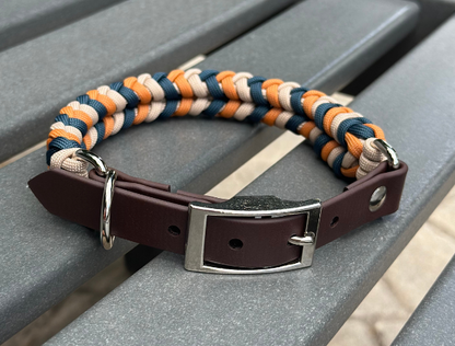 Dog collar with brown leather strap and colorful braided design on a gray surface