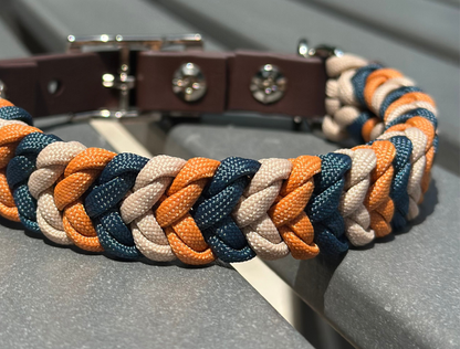 Dog collar with braided design in blue, orange, and beige on a gray surface.