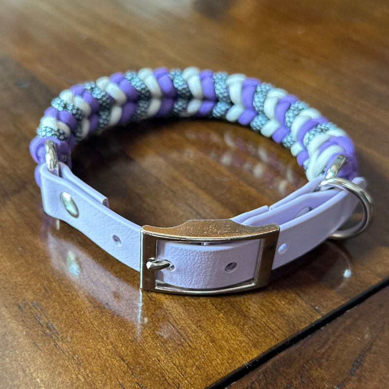 Braided dog collar with purple and beige pattern on a wooden surface