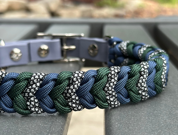 Paracord dog collar with metal buckle on a wooden surface