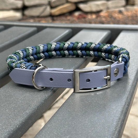Dog collar with braided design and purple leather strap on a metal surface.