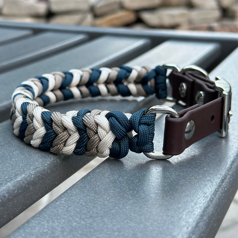 Dog collar with braided design and leather strap on a metal surface