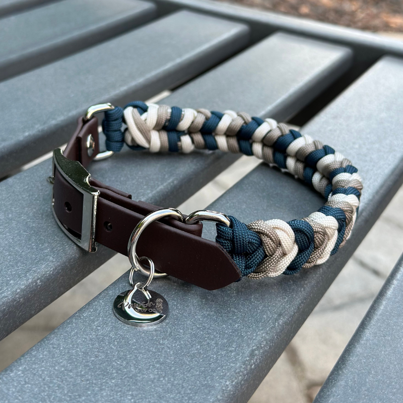 Dog collar with braided design and leather strap on a metal surface