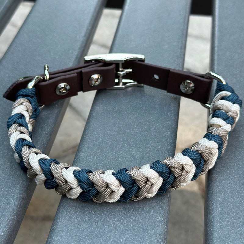 Braided dog collar with brown leather strap on a metal bench