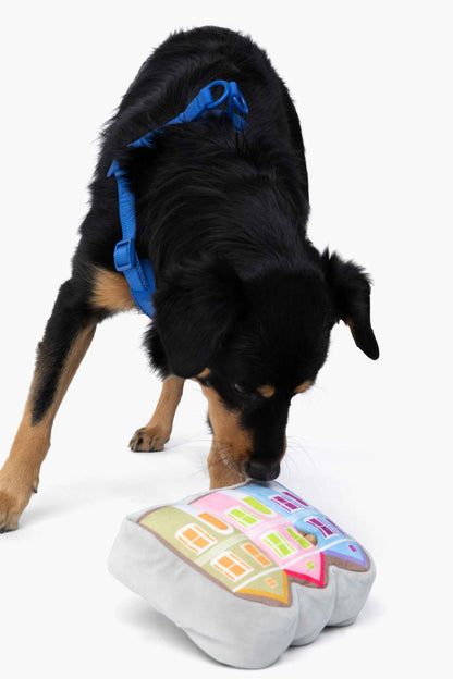 Painted Ladies Nose Work Dog Toy with black and brown dog playing with toy on white background