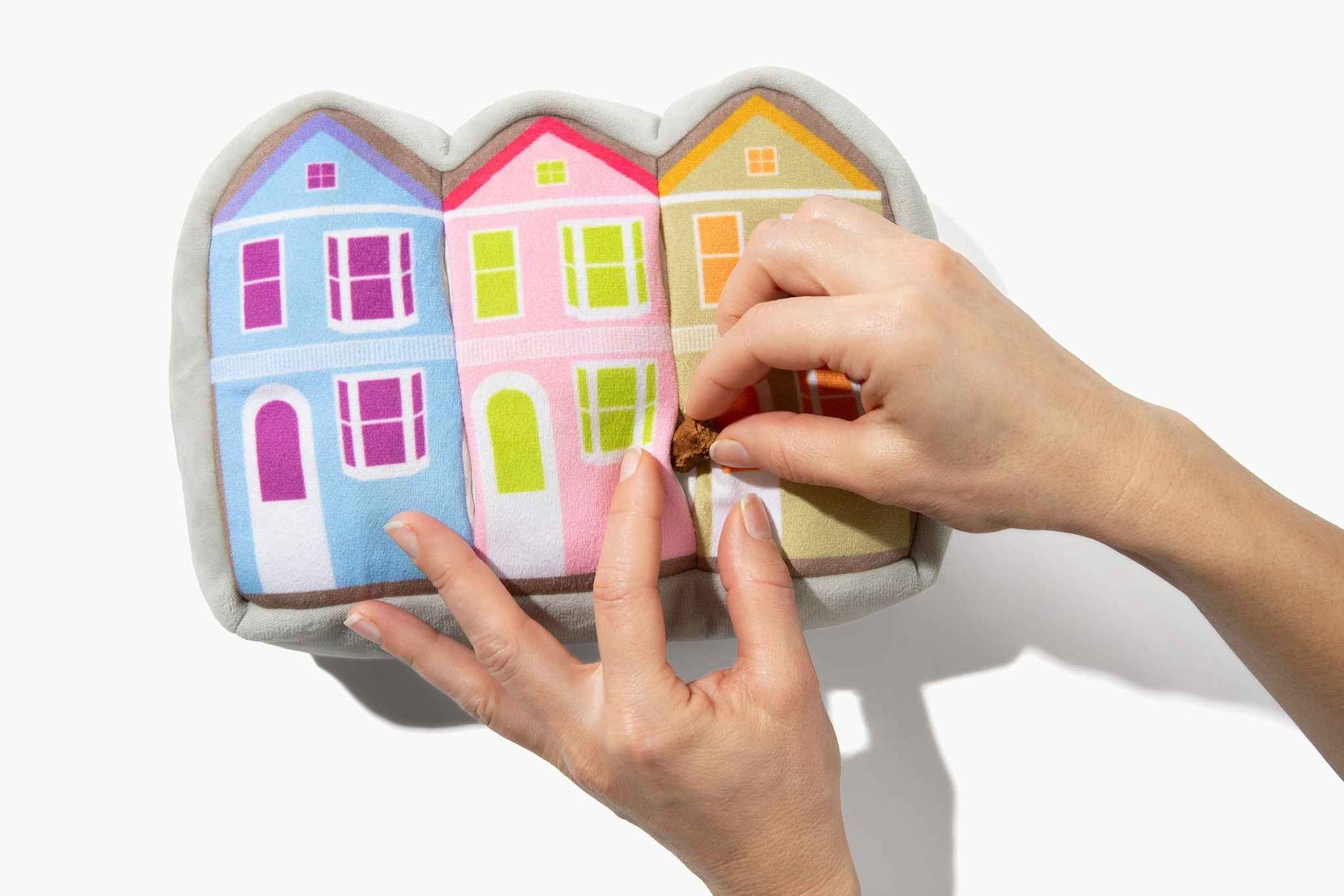 Painted Ladies Nose Work Dog Toy with woman's hands putting treat in toy on white background