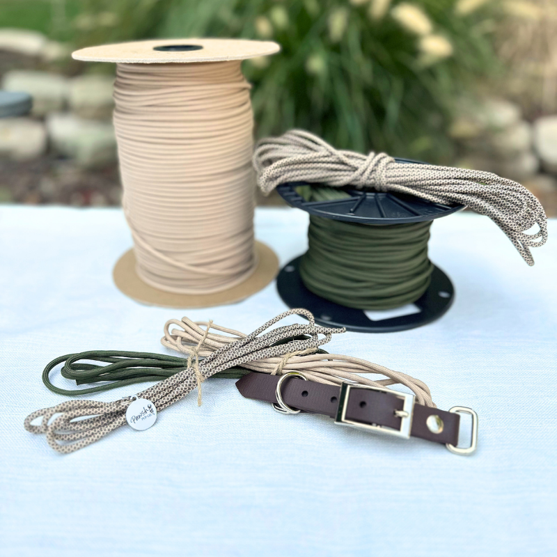 Spools of beige and green cord with a leather belt on a white surface.