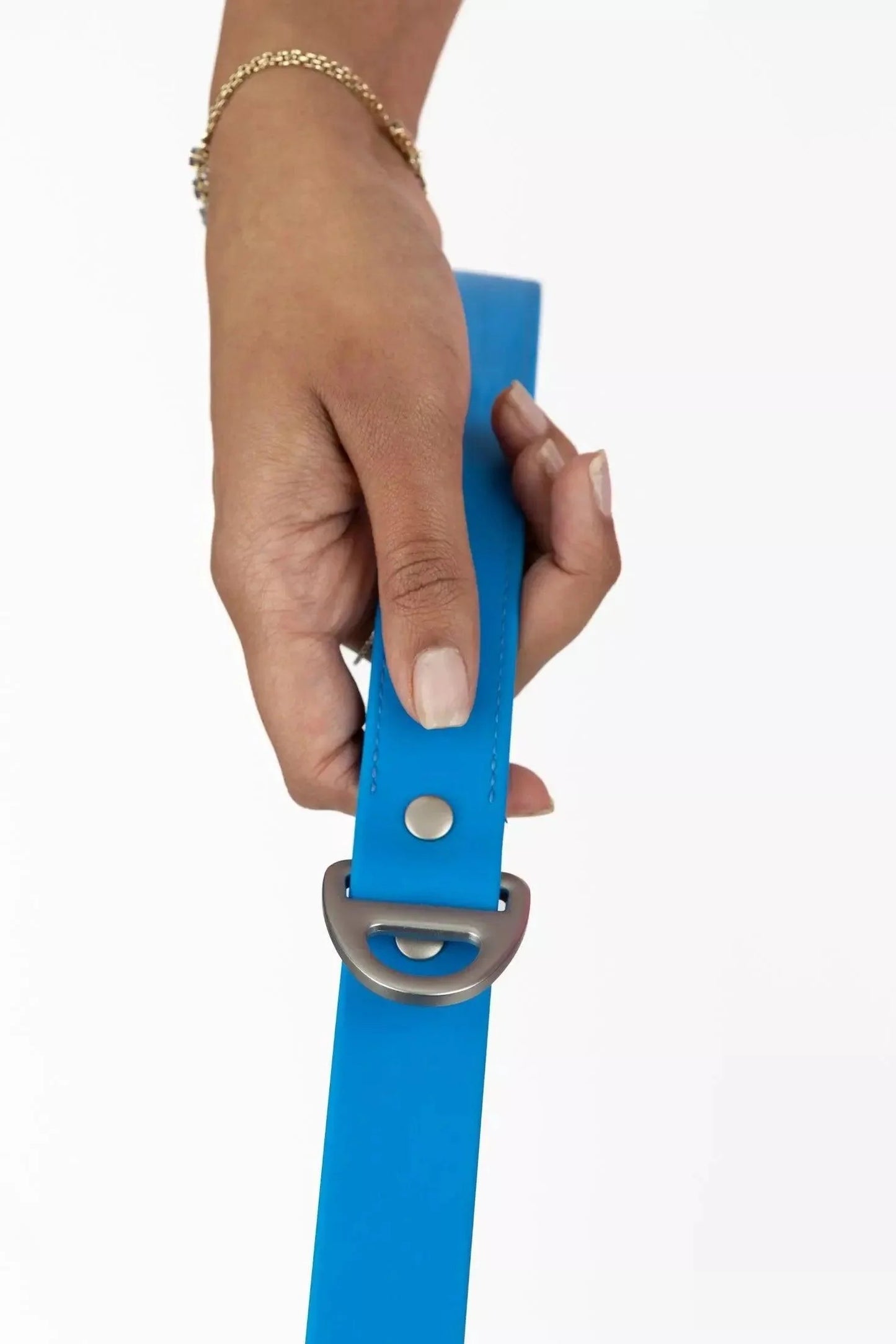 Hand holding a blue strap with a metal buckle on a white background