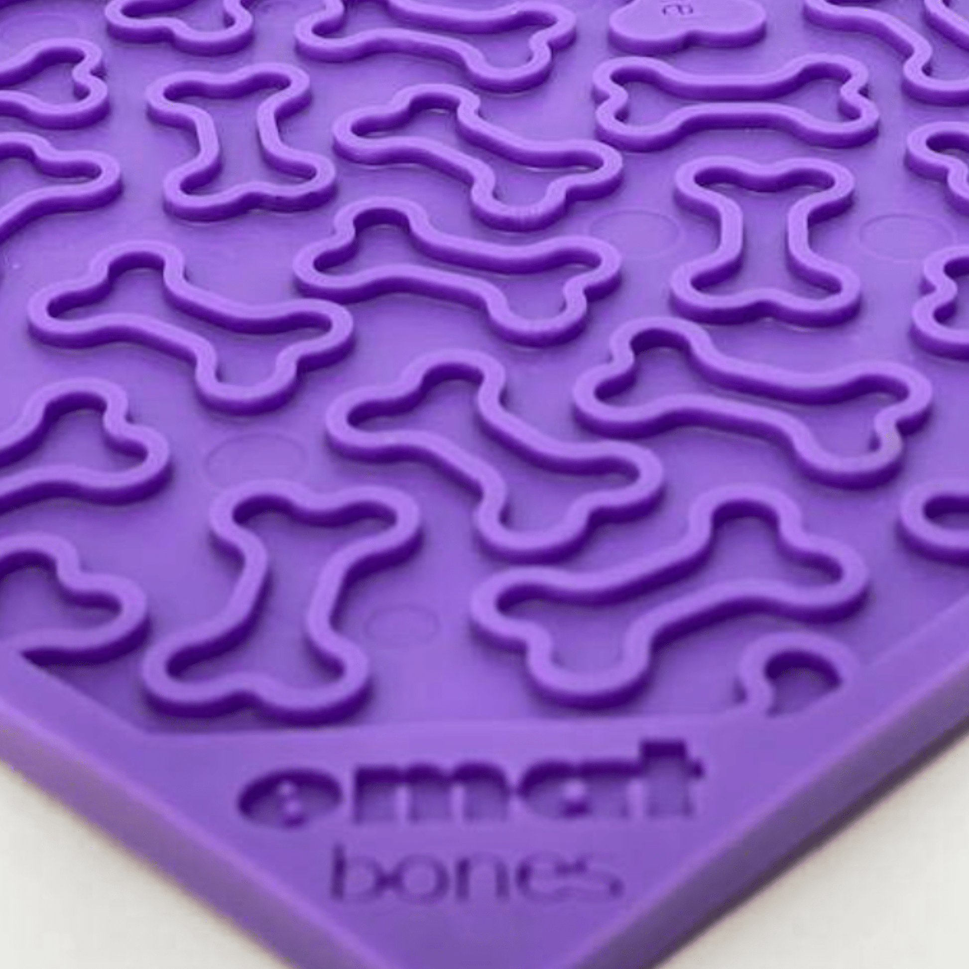 Purple silicone mat with bone shapes on a white background