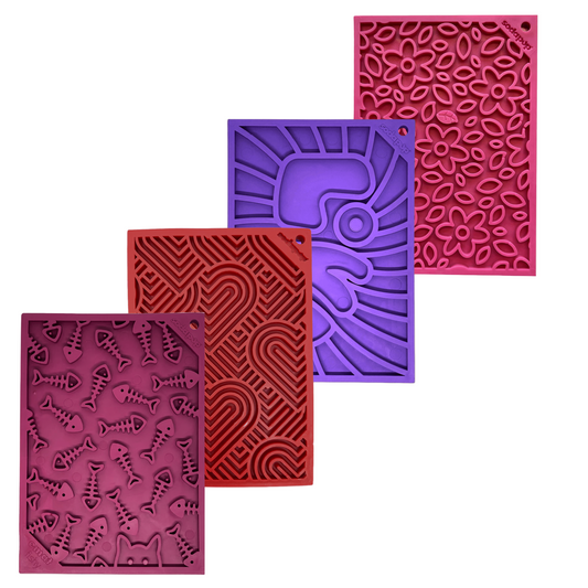 Four silicone dog lick mats with different patterns on a white background