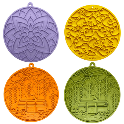 Four round silicone lick mats with unique patterns on a beige background
