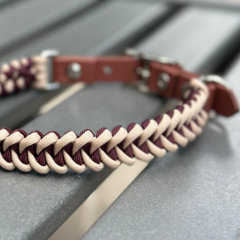 Braided leather dog collar with burgundy and beige pattern on a metallic surface
