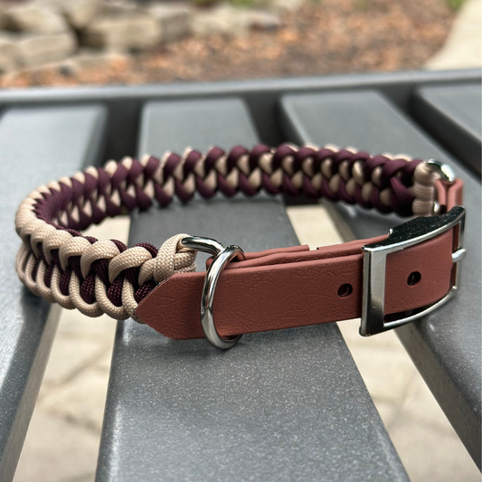 Dog collar with braided design and leather strap on a metal surface