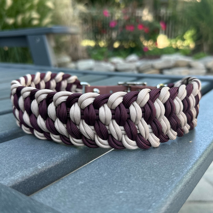 Dog collar with braided design in burgundy and light tan with medium brown BioThane strap on a gray surface outdoors.