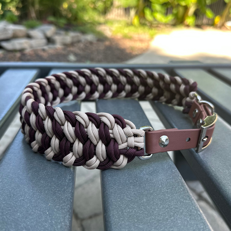 Dog collar with braided design in burgundy and light tan with medium brown BioThane strap on a gray surface outdoors.