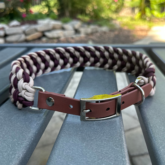 Dog collar with braided design in burgundy and light tan with medium brown BioThane strap on a gray surface outdoors.