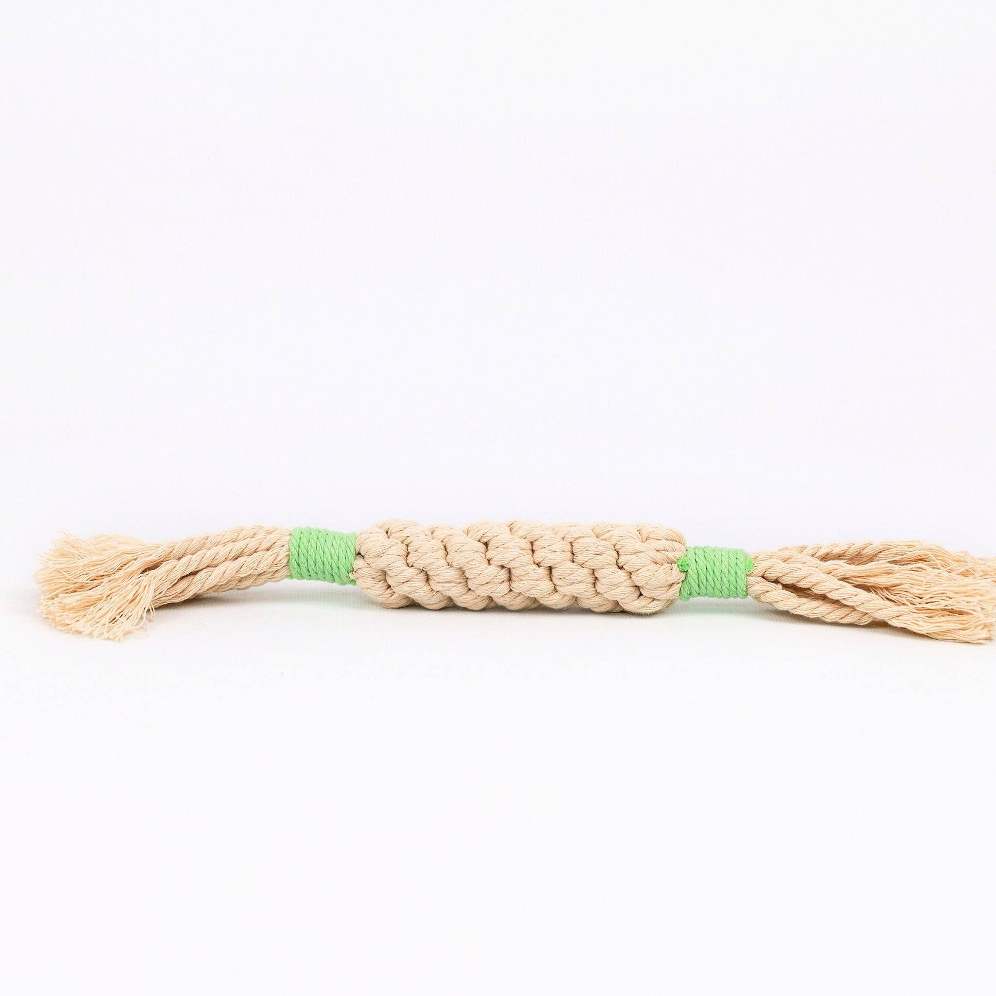 Beige dog toy rope with green accents on a white background