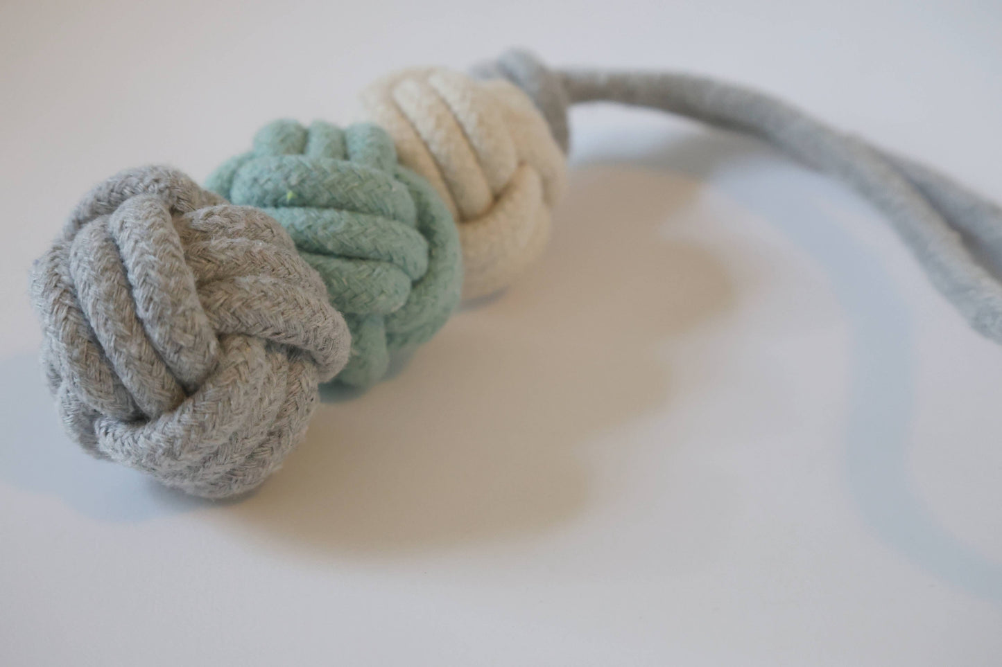 Knotted fabric dog toy with a rope on a white background