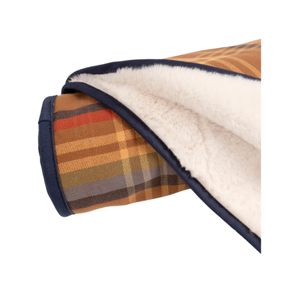 Folded plaid blanket with white fleece lining on a white background