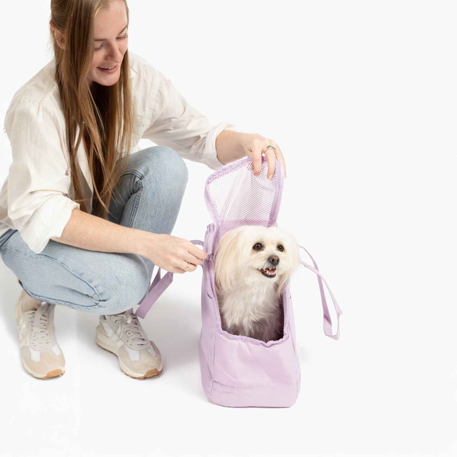 Come Here Buddy Pet Tote Bag in light pink with white dog in it and woman kneeling by it