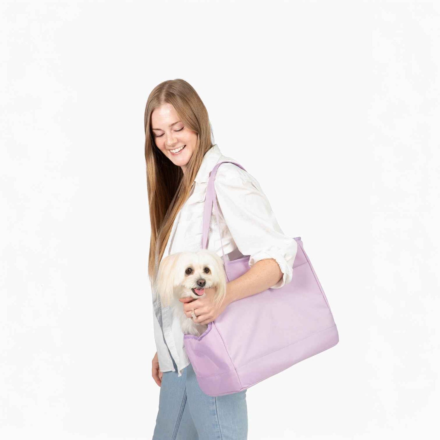 Come Here Buddy Pet Tote Bag in light pink with small white dog in it, hanging on woman's arm