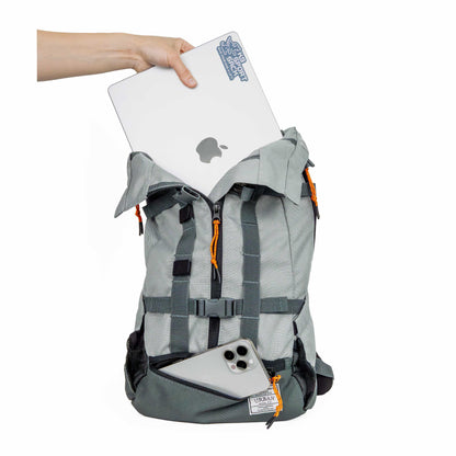 Gray backpack with a laptop and phone, held by a hand on a white background