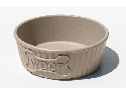 Beige dog bowl with 'WOOF' engraving on a white background