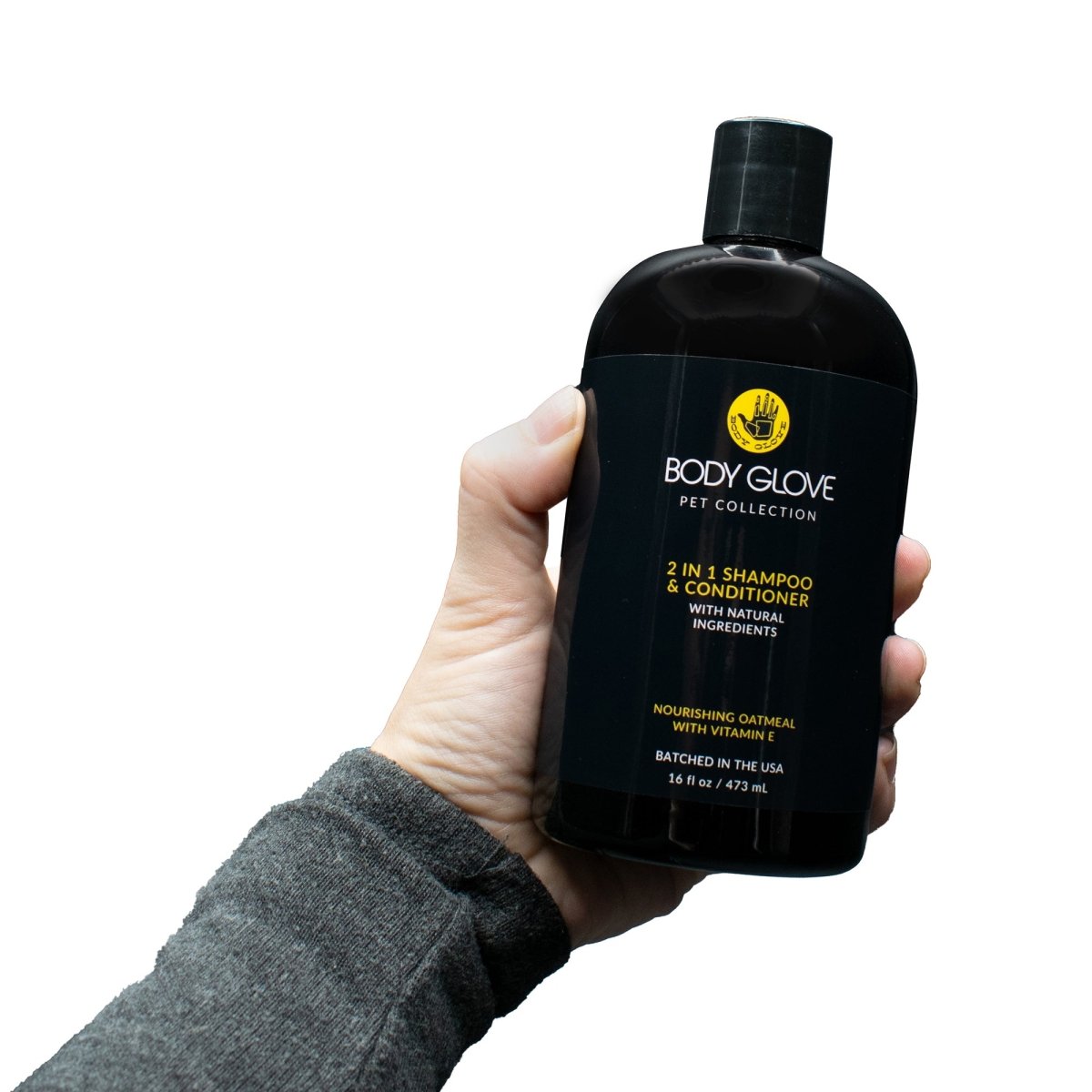 Hand holding a black 'Body Glove Pet Collection' shampoo and conditioner bottle against a white background
