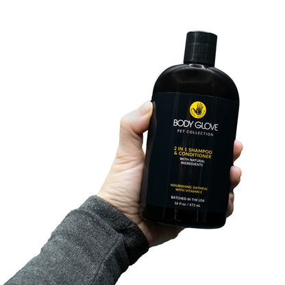 Hand holding a black 'Body Glove Pet Collection' shampoo and conditioner bottle against a white background