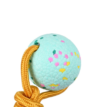 Light blue ball with colorful patterns and a yellow rope on a white background