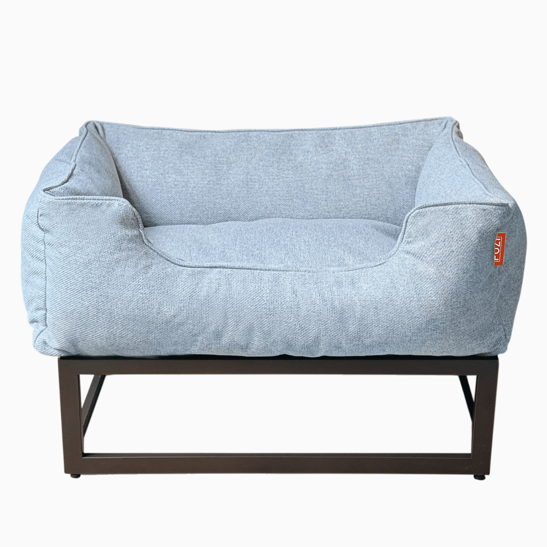 Light blue pet bed with brown frame on a white background