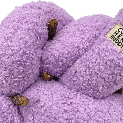 Purple textured dog tow with dog treats tucked in with a visible brand label on a white background