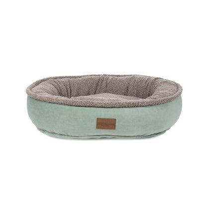 Pet bed with a brown interior and light green exterior on a white background