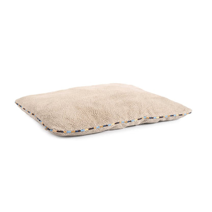 Beige pillow with a textured edge on a white background