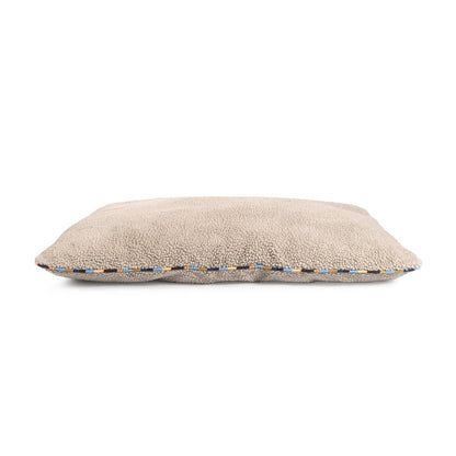 Beige pillow with a textured edge on a white background