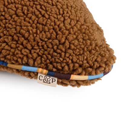 Brown sherpa fabric product with a brand label on a white background